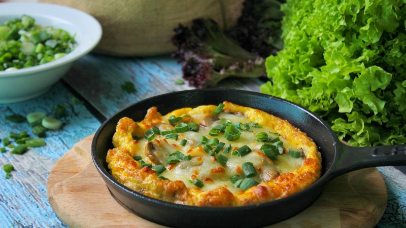 Delicious frittata topped with herbs, served in a skillet alongside fresh greens., tags: für ein - pexel
