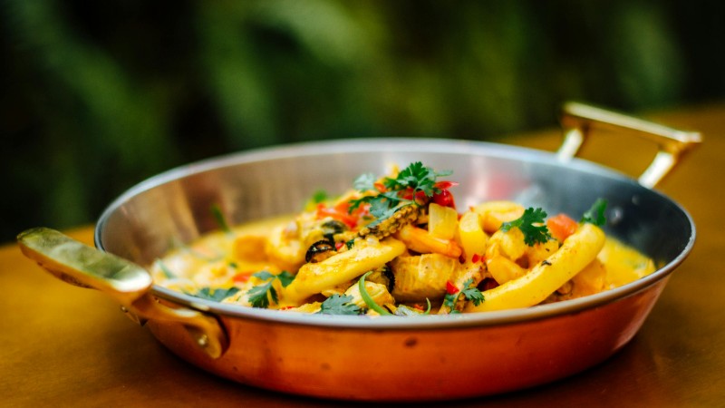 Delicious seafood pasta served in a copper pan, showcasing vibrant ingredients and colorful presentation., tags: und - pexel